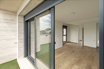 Large social space with walnut-toned wood floors, recessed niches for decorative lighting, and a view. Garden panorama