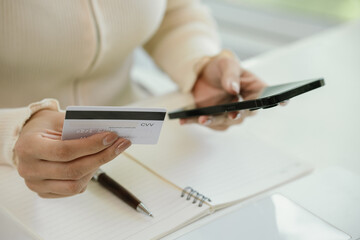 A businesswoman uses her laptop for online banking and e-commerce, managing payments, shopping, and...