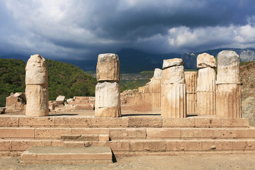 Travel in Turkey. Ruins of Phaselis Ancient City showcase impressive stone columns against a dramatic cloudy sky, highlighting historical architecture and natural beauty
