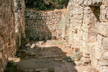 Stone ancient ruins of Phaselis Ancient City in Turkey showcase weathered stone walls and scattered greenery, creating a serene historical atmosphere