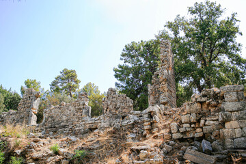 Turkey. Phaselis Ancient City. Ancient ruins of Phaselis City surrounded by lush greenery, showcasing weathered stone structures and historical remnants of a bygone era