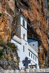 Montenegro, Europe: details of The Monastery of Ostrog, Serbian Orthodox Church dedicated to Saint Basil of Ostrog situated against the vertical background of the large rock Ostroka Greda