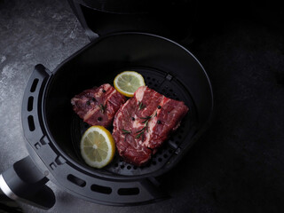 Fresh  beef steak with ingredients and lemon slices, rosemary prepare to be cooked on black...