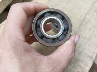 hand holding a used bearings , used engine bearings on motorbikes.