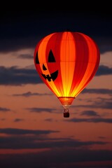 Obraz premium Halloween hot air balloon gliding across twilight sky, pumpkin faced design capturing seasonal whimsy and autumnal magic