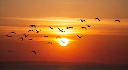 Obraz premium A flock of birds soars gracefully against the backdrop of a vibrant sunset, creating a serene and picturesque moment of freedom and natural beauty