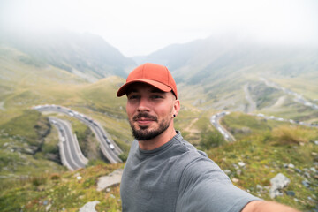 Tourist taking selfie at transfăgărășan highway in the carpathian mountains