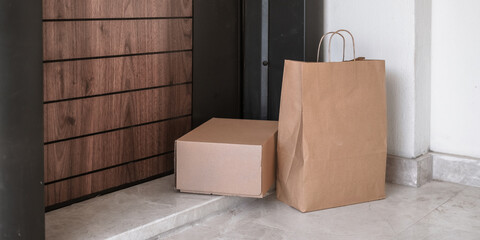 Young woman receiving contactless eco-friendly delivery at home. Paper bags, no plastic, Gen Z...