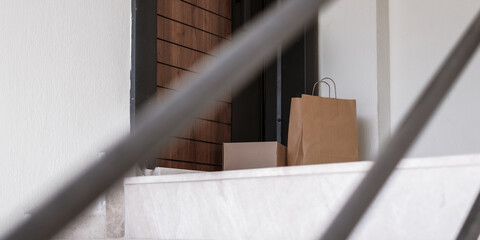 Young woman receiving contactless eco-friendly delivery at home. Paper bags, no plastic, Gen Z...