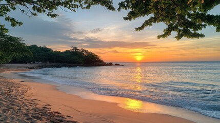 Golden sunset over tranquil beach. Lush tropical foliage frames the scene