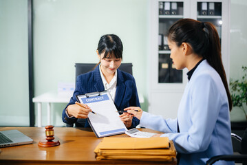 Professional female lawyers consulting on legal cases in a modern office. Perfect for law,...