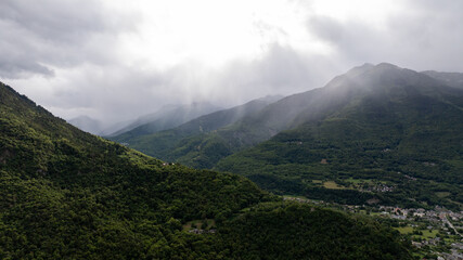 Dramatic landscape of rain falling on green mountains and valley in the french Alps, Auvergne rhone...