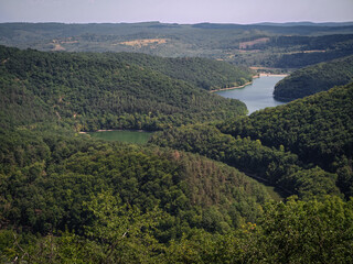 Wide view from Eszkála-tető showing two branches of the Lázbérc Reservoir surrounded by...