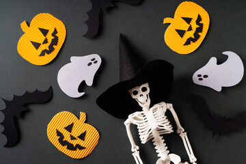 Halloween flat lay with skeleton, pumpkins, bats and ghosts