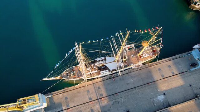Tall sailing ship Mircea, the Romanian Navy&rsquo;s training vessel, docked in the port of Durr&euml;s, Albania at sunset. Historic three-masted barque with full rigging. Drone aerial view.