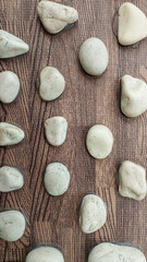 The arrangement of white natural stone on a wood textured surface is suitable for use as wallpaper.