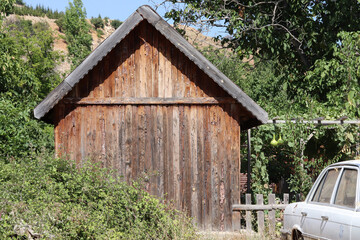Antique car in front of wooden house