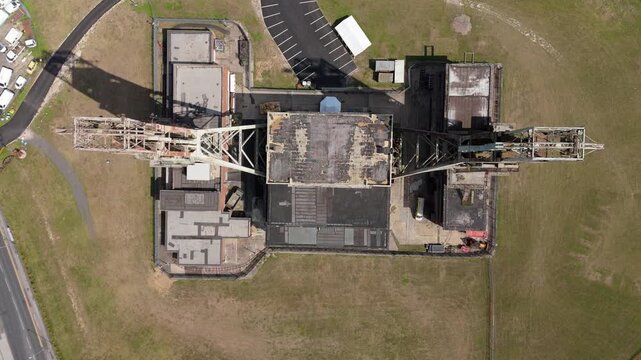 Aerial view of the weathered Headstocks at Clipstone, a stark industrial structure amidst the green landscape, Clipstone, Nottingham, United Kingdom.