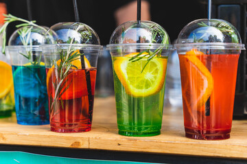 Colorful cocktails sitting on a wooden countertop at an outdoor market