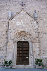 Stone doorway with wooden door and detailed sculptures on the facade of the Cathedral of...