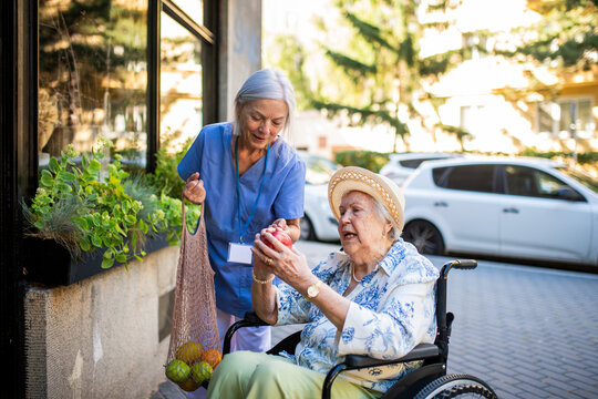Home caregiver assisting older woman during grocery run - Powered by Adobe