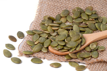 Pumpkin seeds. Raw pumpkin seeds on hemp sackcloth  and wood spoon