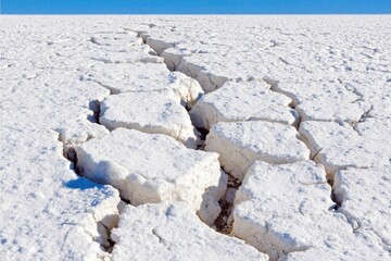 Cracked white salt flat under a clear blue sky