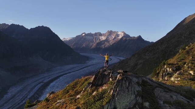 Aerial view of the Aletsch Glacier snaking between the mountains, showcasing the stark contrast of ice and rock, Fieschertal, Valais, Switzerland.