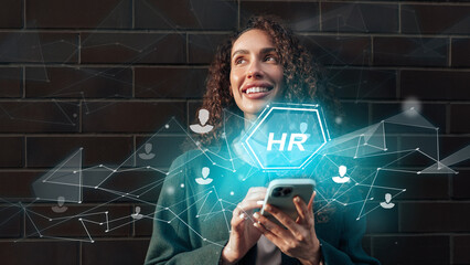 HR professional engaging with technology while smiling outdoors during daytime