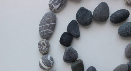 A ring of grey stones inside a ring of smooth pebbles with quartz inclusions 
