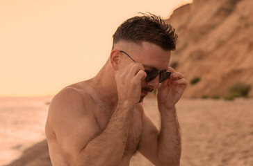 Handsome man in sunglasses on the beach
