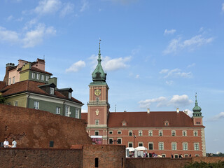 Obraz premium Historic Royal Castle in Warsaw, Poland, showcases stunning architecture with a clock tower and vibrant sky, a symbol of cultural heritage and history