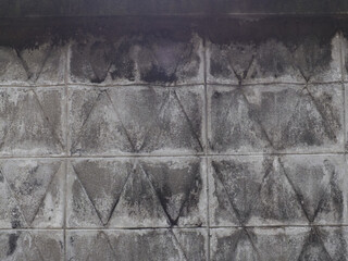 Image shows close up of weathered and stained tiled wall with visible dirt, grime, and...