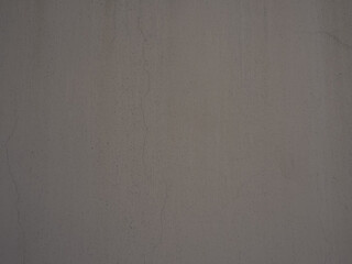 Close up of gray concrete wall with visible cracks and texture, conveying raw, industrial, and weathered appearance with subtle shading