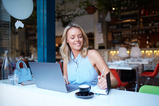 Young woman freelancing from her laptop at cafe