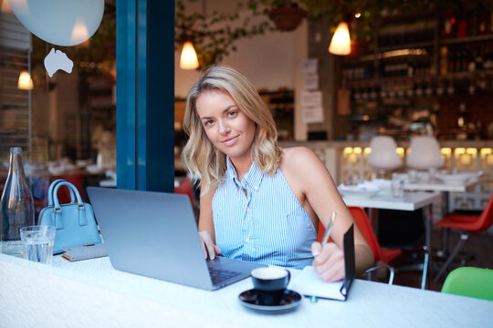Young woman freelancing from her laptop at cafe