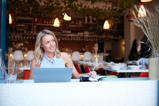 Young woman freelancing from her laptop at cafe