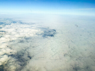 Wide aerial view of dense cloudscape at high altitude. Natural texture, atmospheric movement, and soft visual patterns in the sky.