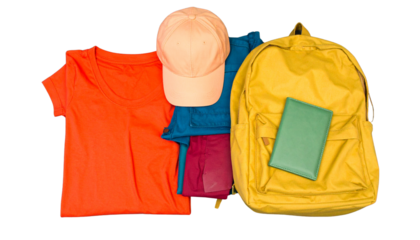 A folded orange t-shirt, a light peach baseball cap, a mustard yellow backpack, and a teal green wallet laid out on a black surface