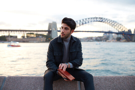 Tourist checking phone with the Sydney Harbour Bridge in background