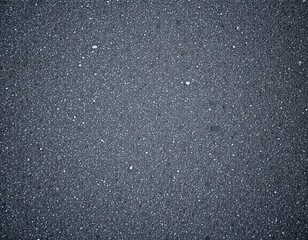 Close-up texture shot of asphalt surface, showcasing fine details and subtle variations in color. It could be used for construction, road surface or background texture