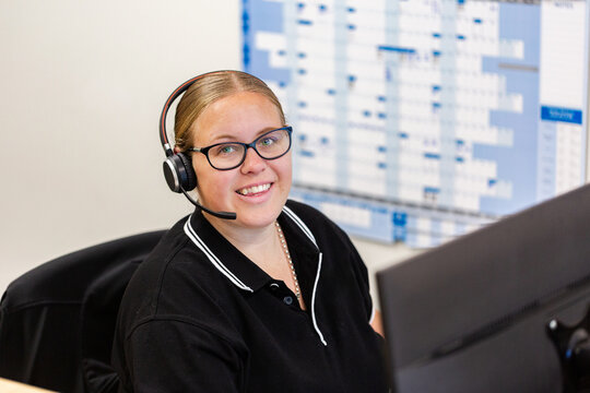female administrate staff lady sitting by computer at front desk office