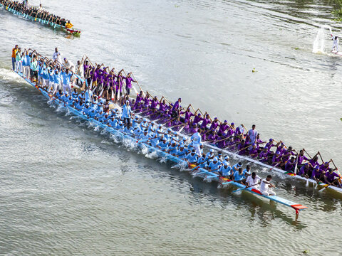 Brahmanbaria, Bangladesh - 07 September 2023: Aerial view of sleek racing boats, vibrant in shades of blue and purple, cutting through the shimmering water, propelled by synchronized rowers.