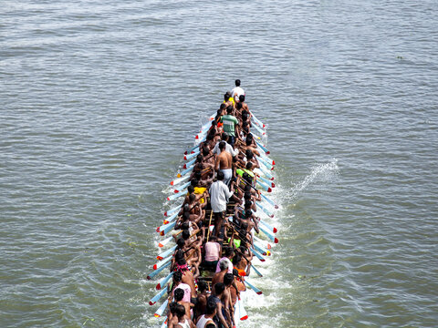 Brahmanbaria, Bangladesh - 01 January 2000: Aerial view of a traditional long boat slicing through the shimmering waters, propelled by a multitude of rowers in perfect unison.