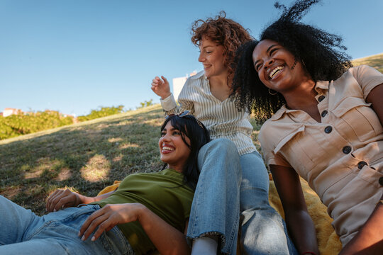 Three young women enjoying a relaxing picnic in the park