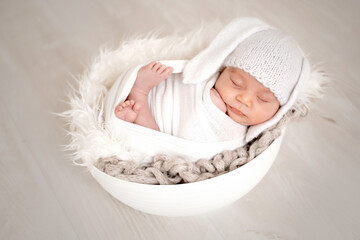 a newborn baby sleeping in a crib, wrapped in a swaddle, the first days of a baby's life