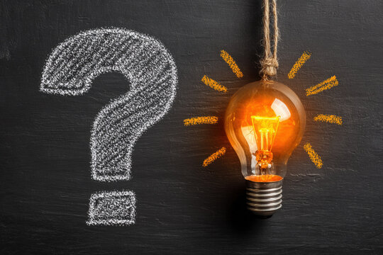 Hand-drawn evolution from question mark to glowing lightbulb on chalkboard