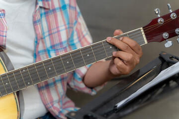 Detailed close-up of a man’s hand forming guitar chords, representing music, creativity, and artistic expression.