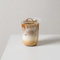 Iced coffee latte in a plastic cup with milk swirl and ice on a clean white background. Minimal studio product shot for cafe menu, branding, and Mockup.
