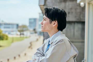 外を見つめる作業着姿の男性